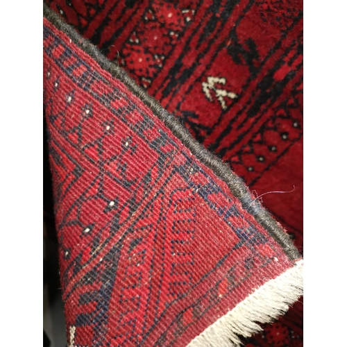 622 - A modern hand knotted Persian rug, red ground, wide multiple border, 20 elephants foot motifs to the... 