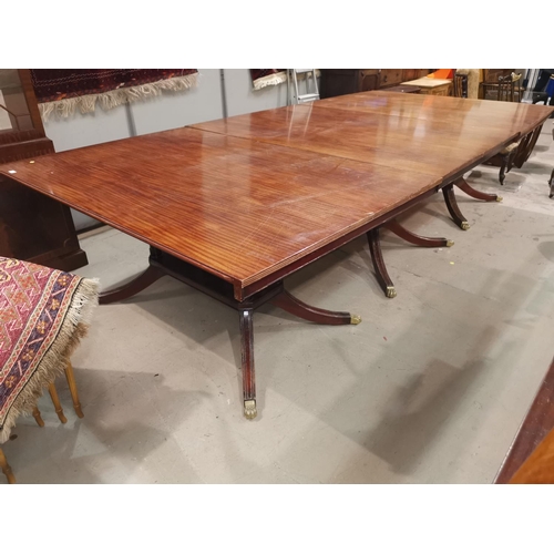 574a - A Regency style large mahogany dining table on triple pedestal with splay feet and castors, extended... 