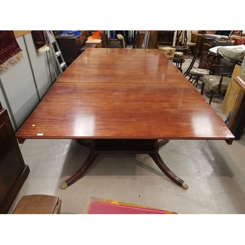 574a - A Regency style large mahogany dining table on triple pedestal with splay feet and castors, extended... 