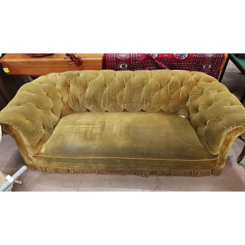 655 - A three seater chesterfield settee with deep button back upholstered in gold length 190 cm on turned... 