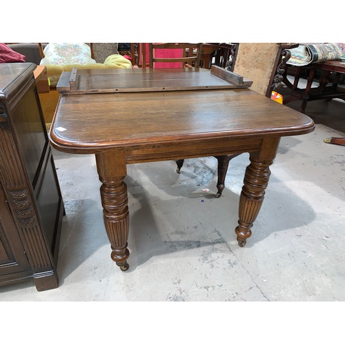 610 - A Victorian oak extending dining table, one spare leaf, on turned legs