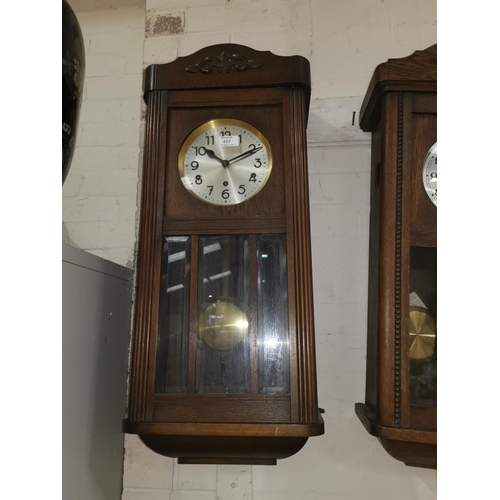 368A - An early 20th century chiming wall clock in oak case; an oak cased barometer with thermometer