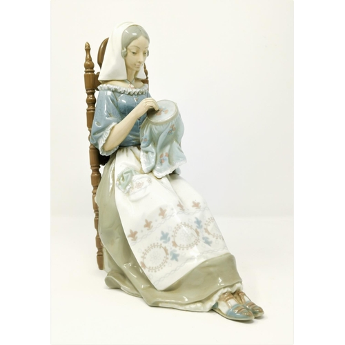 156 - A Lladro figure of woman sewing in high back chair