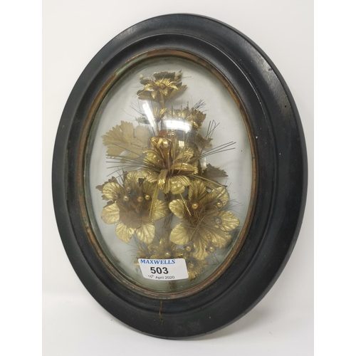 503 - A 19th century gilt work floral trophy under domed oval glass, ebonised frame, 29 x 23 cm overall