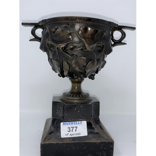 377 - A 19th century bronze 2 handled cup with relief trailing ivy branches, on ebonised base, overall hei... 