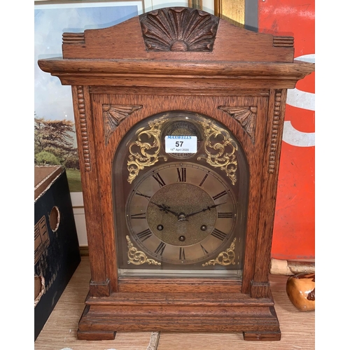 57 - An Edwardian oak mantel clock with brass dial and chiming movement