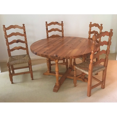 564C - A modern pine dining suite comprising circular table and 4 ladder back rush seat chairs
