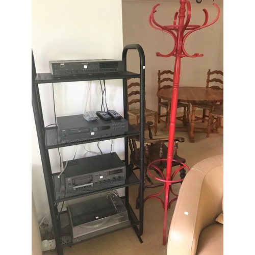 565 - A modern black metal 4 height shelf unit and similar uplight; a red hat and coat stand
