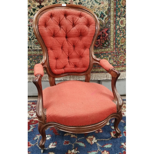 599 - A Victorian mahogany framed spoon back armchair with knurled arms and legs, deeply buttoned in rust ... 