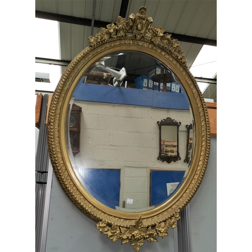 566A - A 19th century oval ornate gilt framed wall mirror