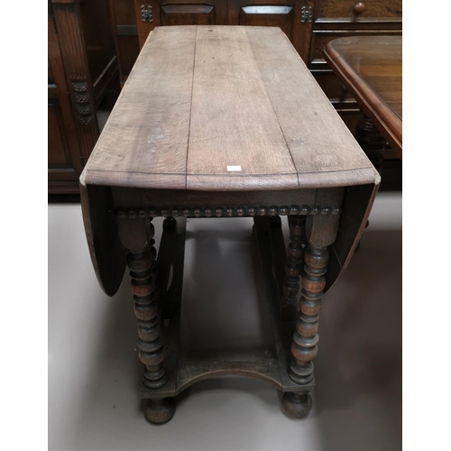 678 - A Late 19th/early 20th oak drop leaf dining table with turned legs