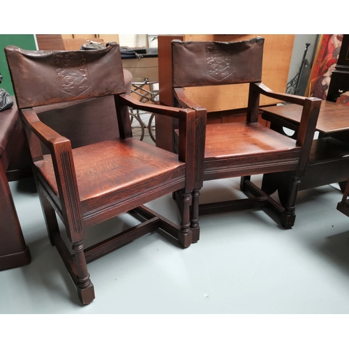 689 - A pair of Arts and Crafts oak armchairs with leather upholstery and embossed lines