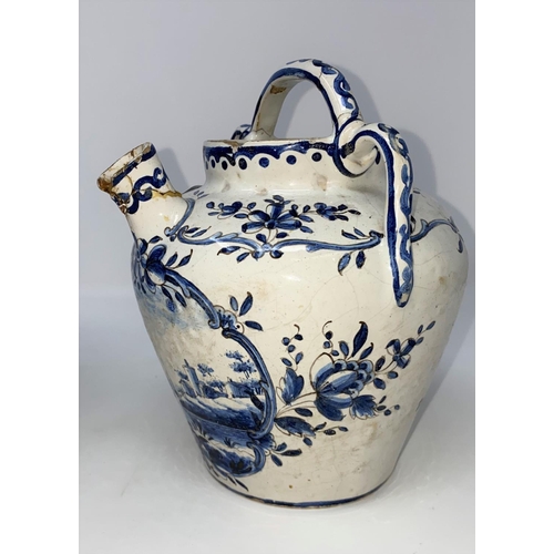 303 - An 18th / 19th century Delftware tin glazed jug with handle and spout decorated in blue and white wi... 