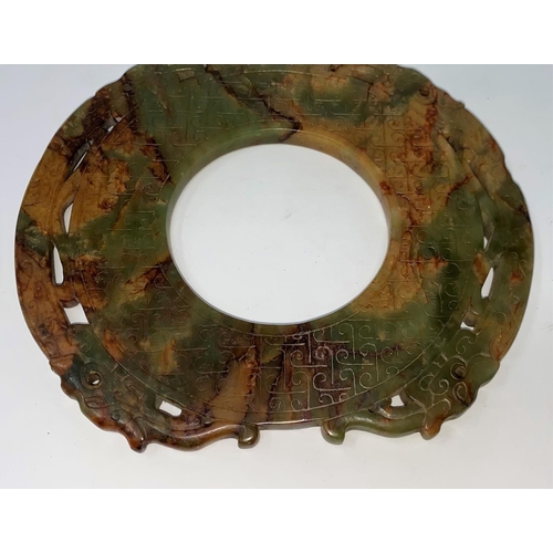 309a - A Chinese carved jade colour stylized circular stone with incised decoration, on hardwood stand (res... 
