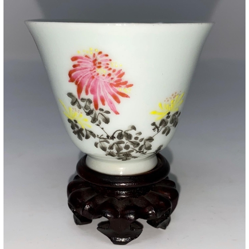 312 - A Chinese porcelain small cup decorated with flowers and characters, on stand, ht 5.5cm