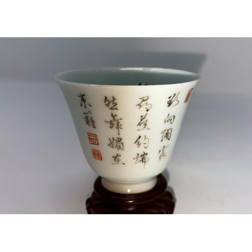 312 - A Chinese porcelain small cup decorated with flowers and characters, on stand, ht 5.5cm