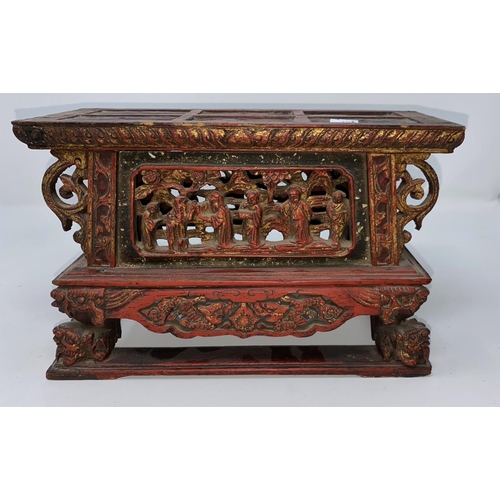 312a - A Chinese wooden tea pot stand in red and gilt with carved and pierced decoration of figures and res... 