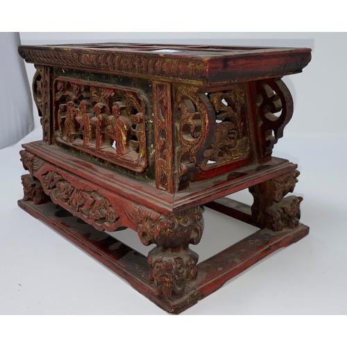 312a - A Chinese wooden tea pot stand in red and gilt with carved and pierced decoration of figures and res... 