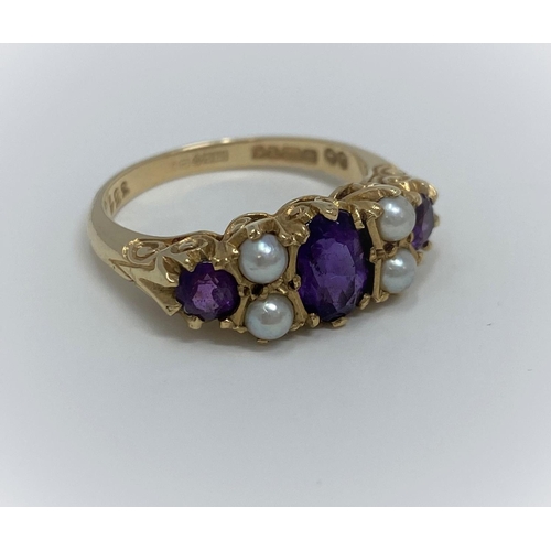 389 - A 9ct dress ring with three amethyst coloured stones and four seed pearls