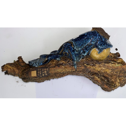 359a - A Chinese figure of a man reclining on log, length 43cm