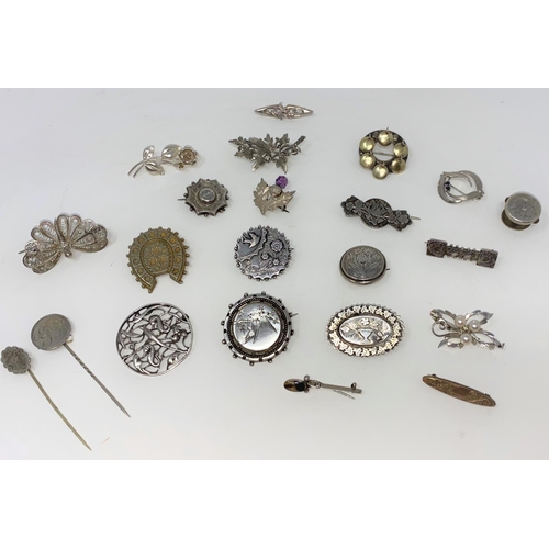 385 - A selection of Victorian and later white metal brooches with embossed and chased decoration