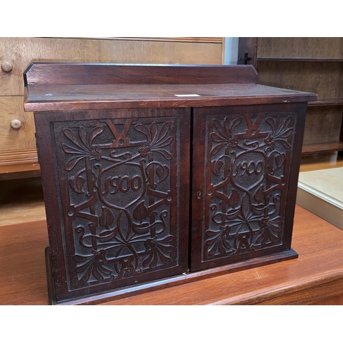 641 - An Edwardian stained mahogany small double cupboard with Macclesfield style carving to the doors, he... 