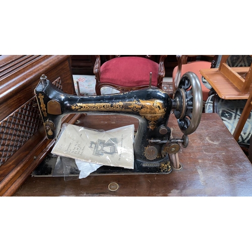 648 - An early 20th century Singer cast iron treadle sewing machine with mahogany cover and top