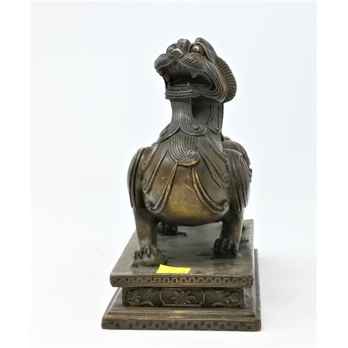 324A - A Chinese bronze sculpture of a mythical winged beast on a plinth length 17cm