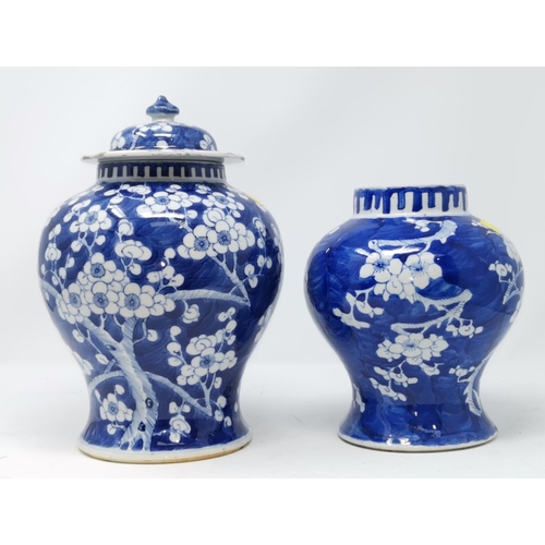 324C - A Chinese blue and white lidded vase decorated with prunus blossom and another similar vase (no lid)