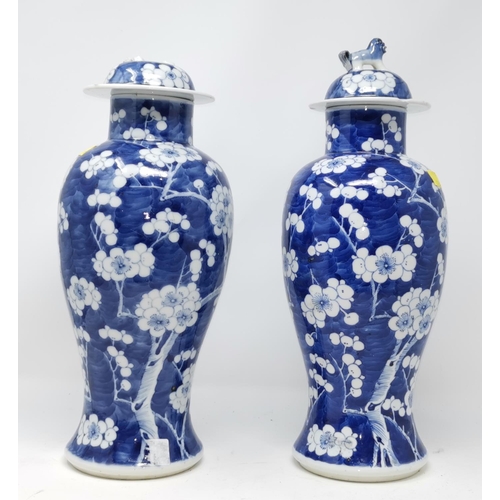 325A - Two Chinese blue and white prunis blossom lidded baluster vases (some restoration) height 39cm