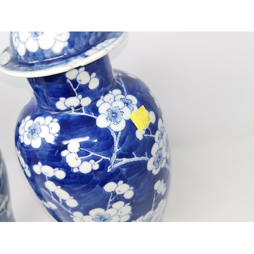 325A - Two Chinese blue and white prunis blossom lidded baluster vases (some restoration) height 39cm