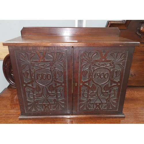 641 - An Edwardian stained mahogany small double cupboard with Macclesfield style carving to the doors, he... 