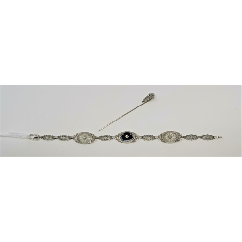 415 - An Art Deco white metal filigree oval link bracelet stamped '14K' tests as 10 / 12 carats, set with ... 