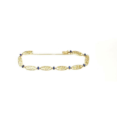 426 - An Edwardian yellow metal bracelet formed from pierced oval links in the form of shamrock leaves int...