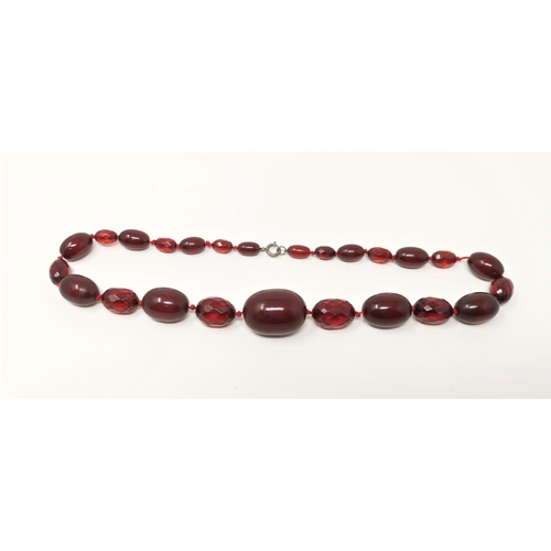 456 - A cherry amber coloured necklace, 62gm, with alternate faceted and polished beads, internal swirl to... 