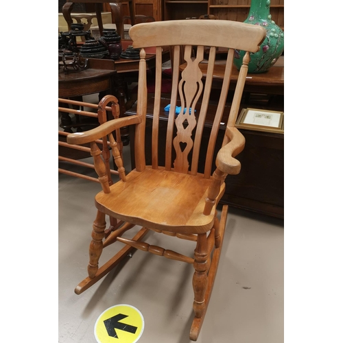 617 - A lightwood rocking armchair with fiddle back