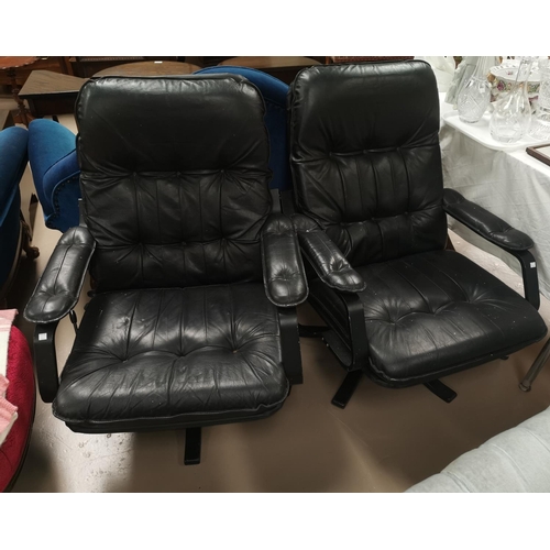 650 - A pair of modern swivel armchairs in black