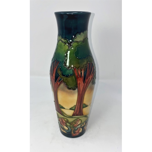 220 - A modern Moorcroft vase of elongated baluster form, decorated with trees in a landscape by Emma Boss... 