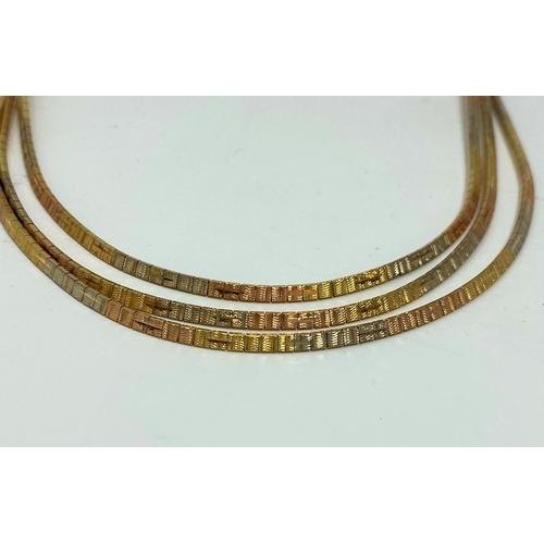 325 - A sectional necklace in 3 coloured gold, stamped '750', weight 27 g