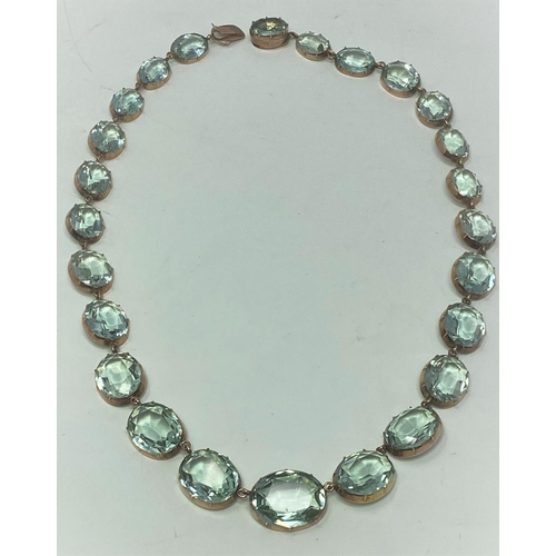 396 - An aquamarine colour faceted stone necklace with yellow metal mounts (tests as 9 carat), 43CM