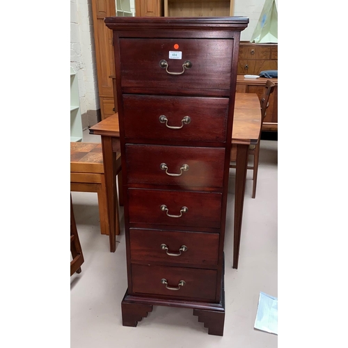 484 - A tall narrow chest of drawers in dark wood;