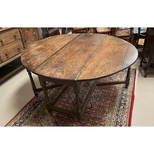 515 - A mid Georgian country made oak and elm dining table with oval drop leaf top, on turned legs, length... 