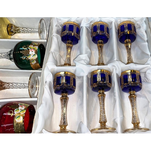 269 - A European set of small wine glasses in blue and gilt; a similar set of Alfa & Omega Italian coloure... 