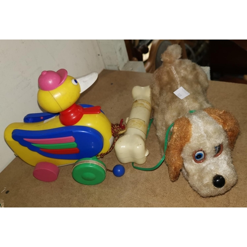 109 - A vintage battery operated toy 'dog and bone'; a pull-along duck toy; a child's potty/highchair (sol... 