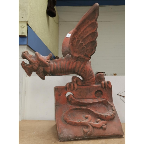 114 - A roof apex/garden ornament in the form of a terracotta coloured dragon, height 57 cm (chip to back ... 