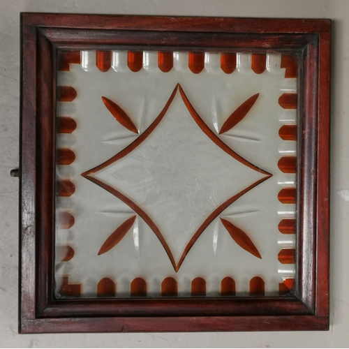 128 - A cut and stained glass window panel with floral motif, in mahogany frame, 34 cm square