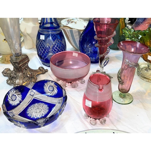 287 - 2 blue overlaid glass decanters; 4 pieces of cranberry glass; an iridescent glass vase on silver pla... 