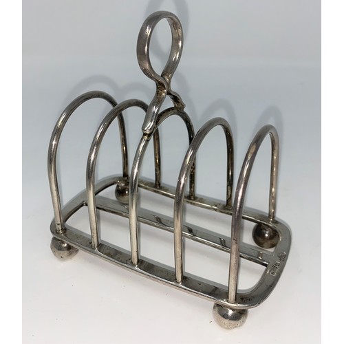 448 - An arched hall marked silver four division toast rack on ball feet Sheffield 1930 5.5oz (172gms) by ... 