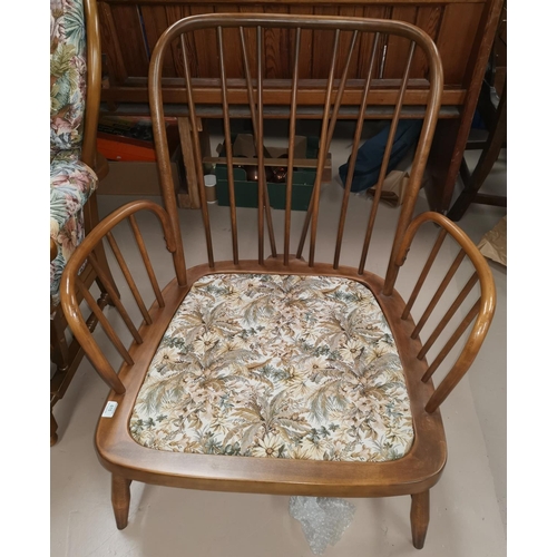 615 - An Ercol stick back armchair with floral upholstery, frame only