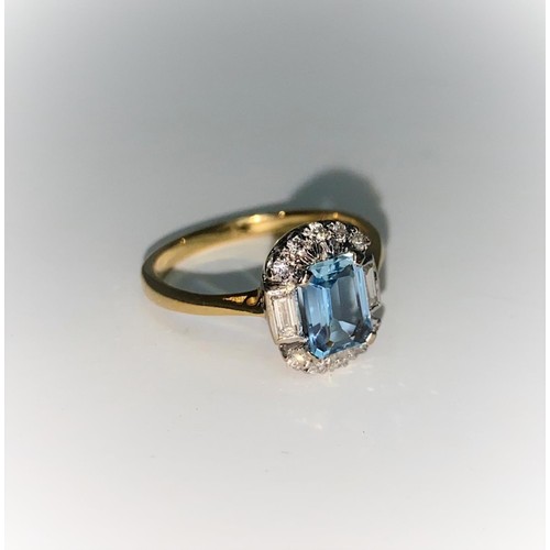 366 - An 18 carat gold dress ring set emerald cut aquamarine flanked by 2 baguette cut and 10 small brilli... 